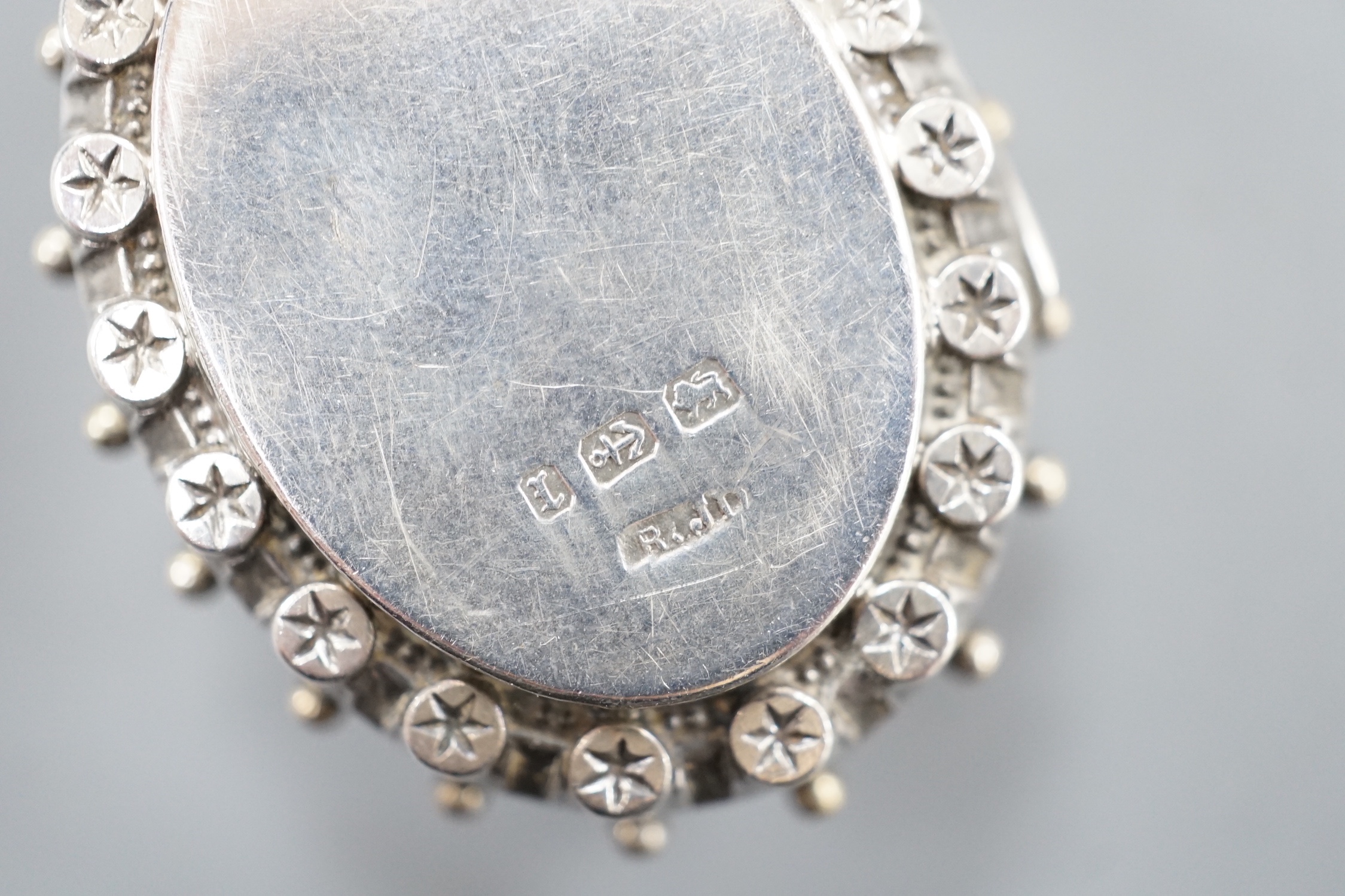 A late Victorian silver oval locket, on a white metal albertina, 49cm.